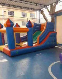 mini tobogã inflável colorido que termina em uma piscina de bolinhas. A melhor opção de aluguel de brinquedos infláveis para os mais novos.